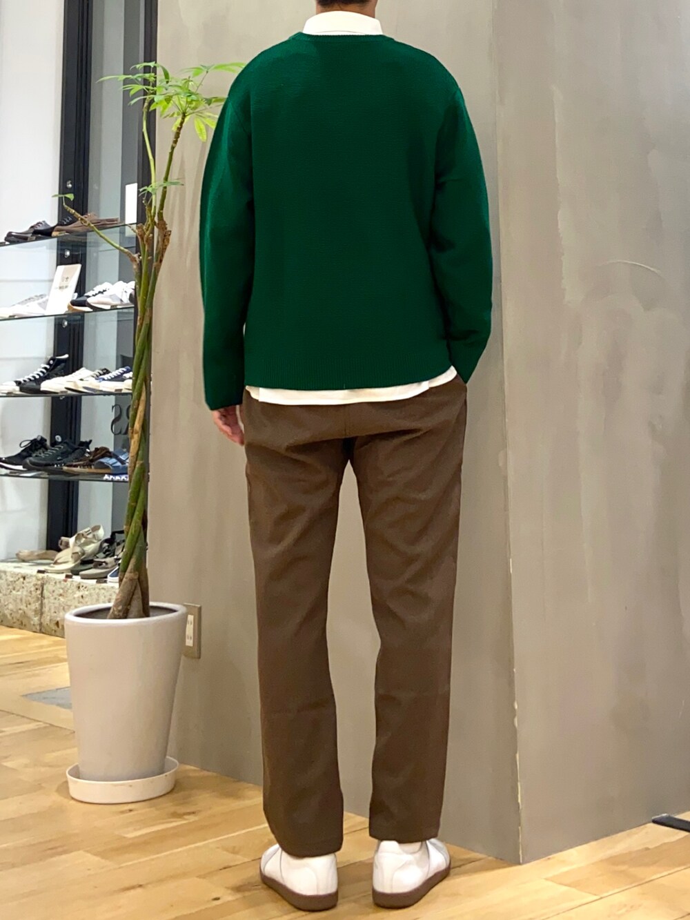 グリーン系のニット/セーター、ホワイト系のシャツ/ブラウス、ホワイト系のスニーカーを着用したメンズの秋コーディネートの4枚目の写真