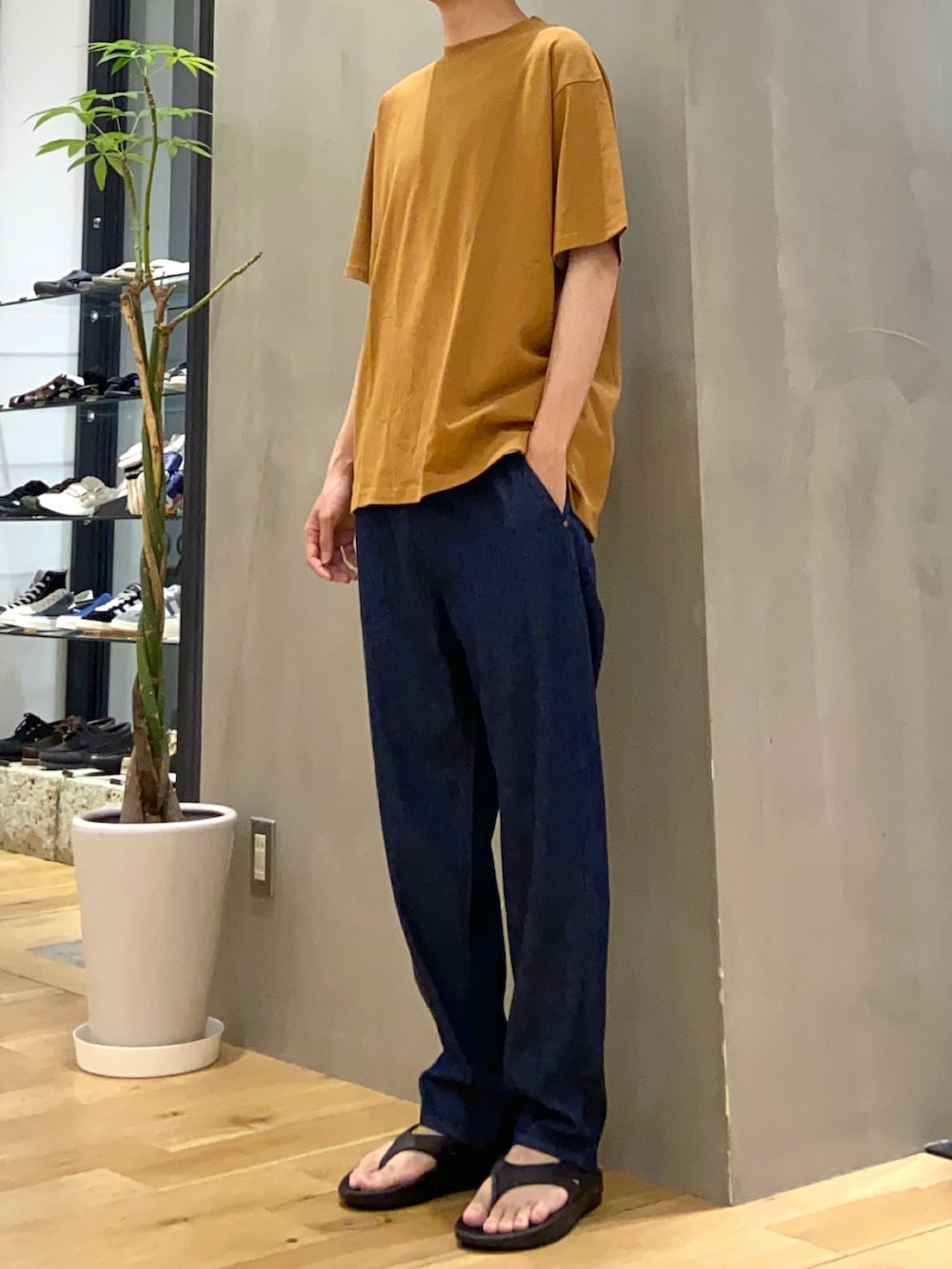 イエロー系のTシャツ/カットソー、ホワイト系のタンクトップ、ブルー系のデニムパンツを着用したメンズの春コーディネートの2枚目の写真