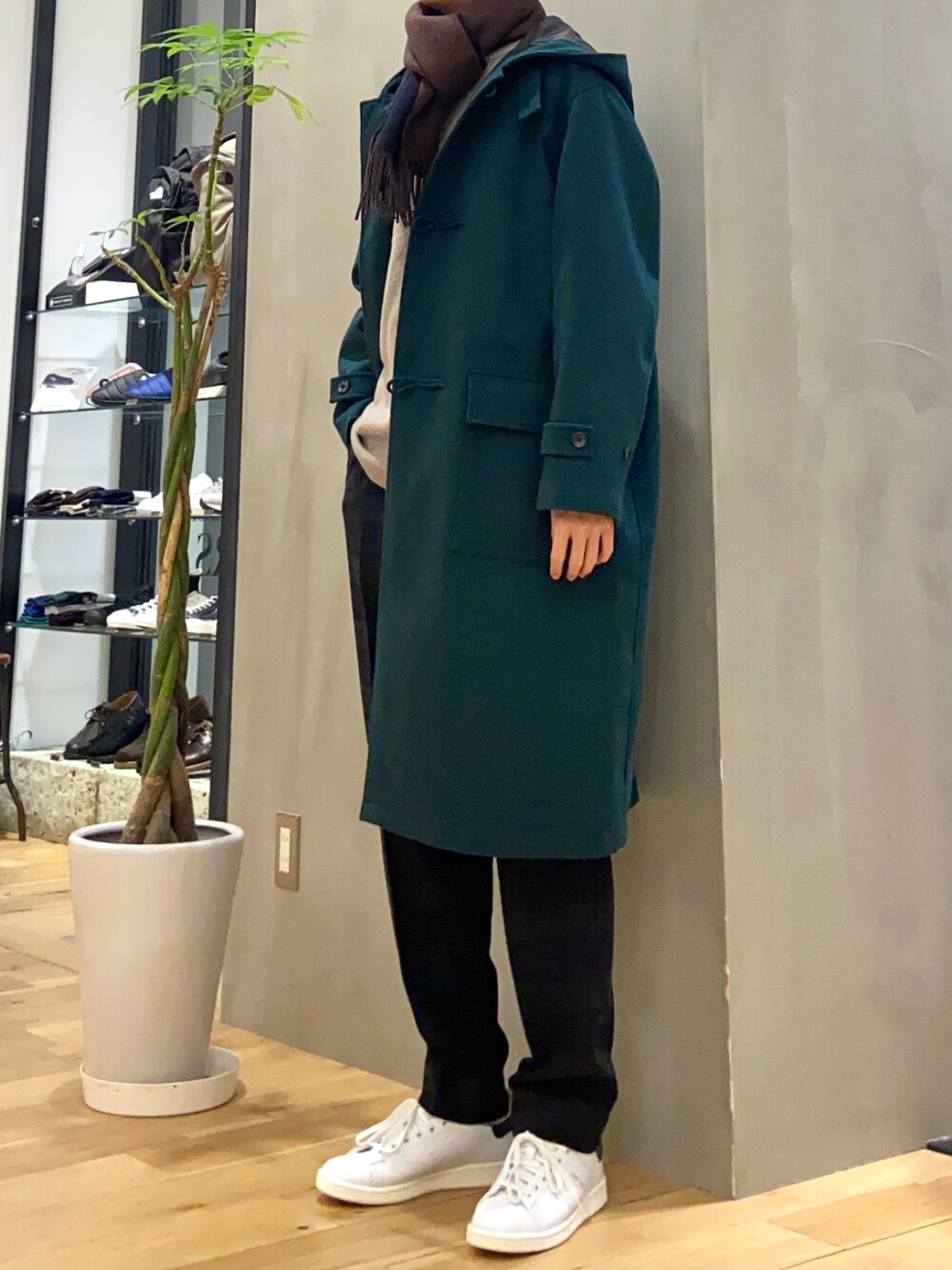 グリーン系のダッフルコート、ブラック系のその他パンツ、ブラウン系のニット/セーターを着用したメンズの冬コーディネートの3枚目の写真