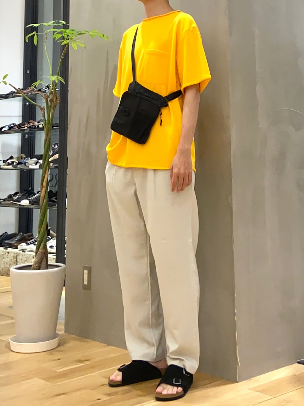 イエロー系のTシャツ/カットソー、ブラック系のショルダーバッグ、ホワイト系のその他パンツを着用したメンズの夏コーディネートの2枚目の写真