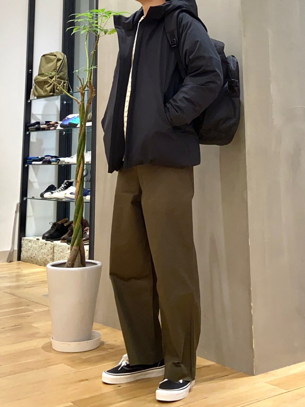 ブラック系のダウンジャケット/コート、ホワイト系のニット/セーター、ブラック系のスニーカーを着用したメンズの冬コーディネートの3枚目の写真