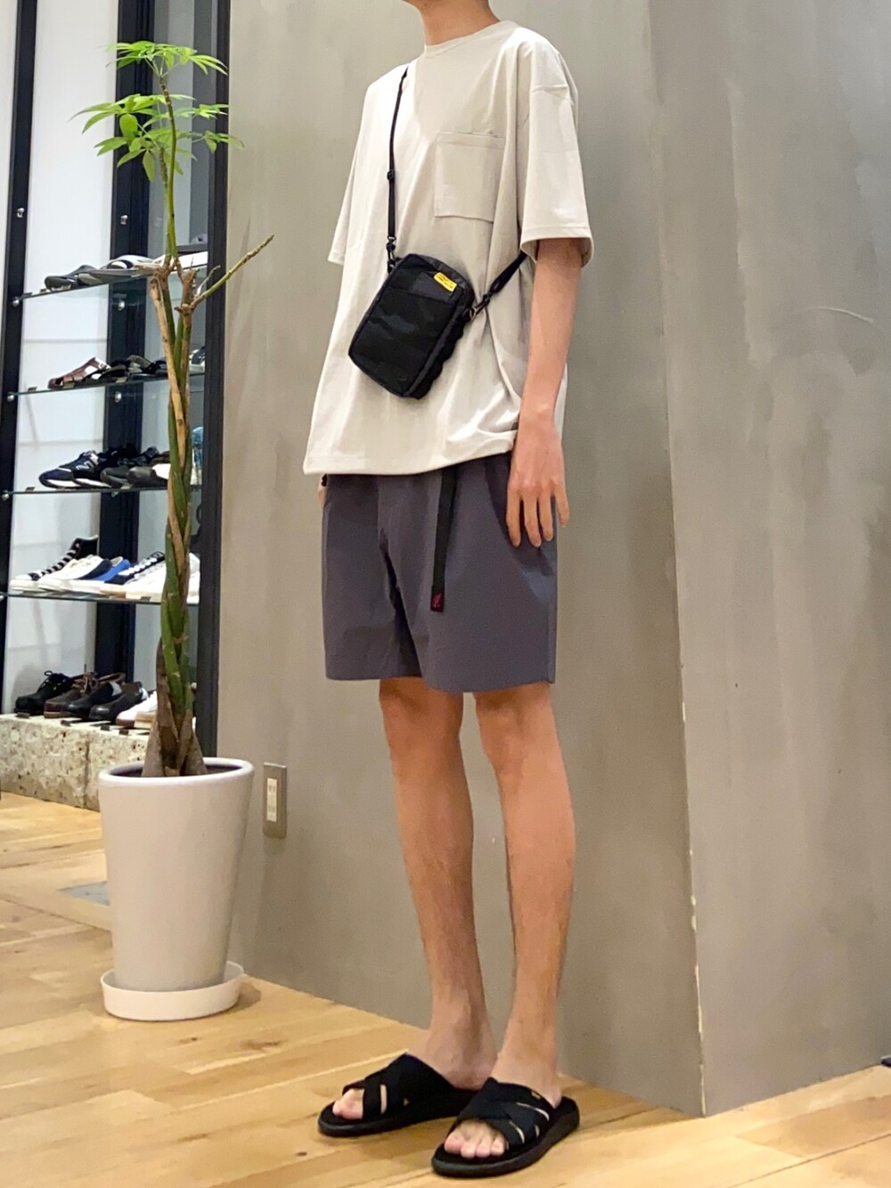 グレー系のTシャツ/カットソー、グレー系のその他パンツ、ブラック系のサンダルを着用したメンズの春コーディネートの2枚目の写真