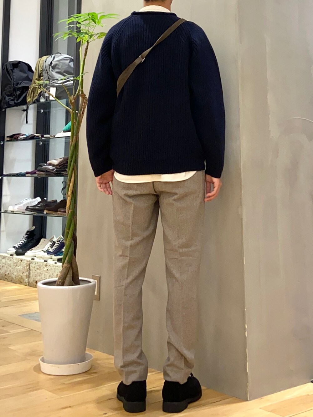 ブルー系のニット/セーター、ブラウン系のショルダーバッグ、ブラック系のその他シューズを着用したメンズの冬コーディネートの3枚目の写真