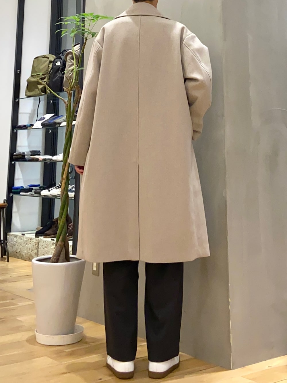 グレー系のチェスターコート、グレー系のシャツ/ブラウス、ホワイト系のスニーカーを着用したメンズの冬コーディネートの3枚目の写真