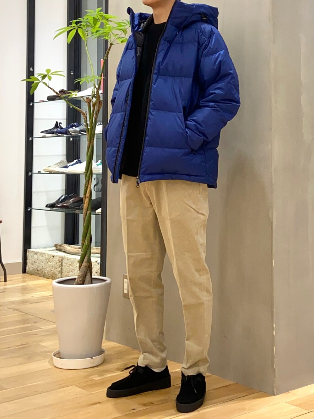 ブルー系のダウンジャケット/コート、ブラック系のニット/セーター、ブラック系のその他シューズを着用したメンズの冬コーディネートの2枚目の写真