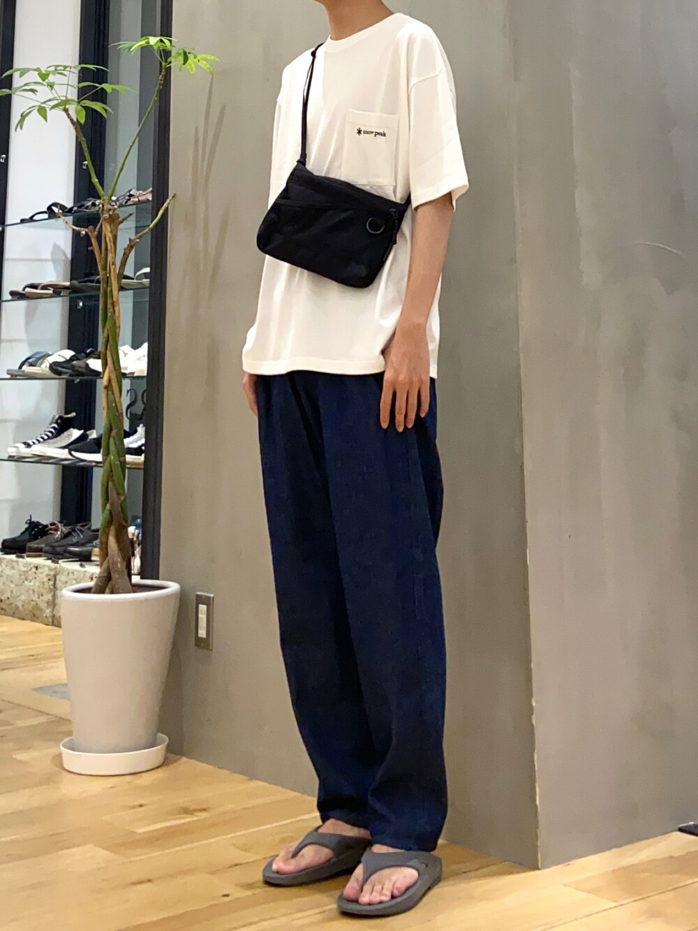 ホワイト系のTシャツ/カットソー、ブルー系のデニムパンツ、グレー系のサンダルを着用したメンズの夏コーディネートの2枚目の写真