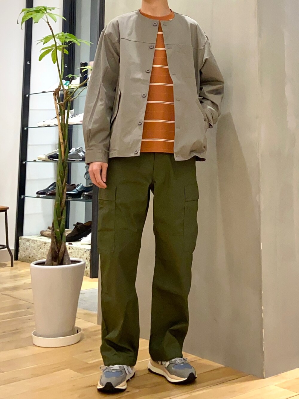 グレー系のブルゾン、オレンジ系のTシャツ/カットソー、グリーン系のその他パンツを着用したメンズの春コーディネートの3枚目の写真