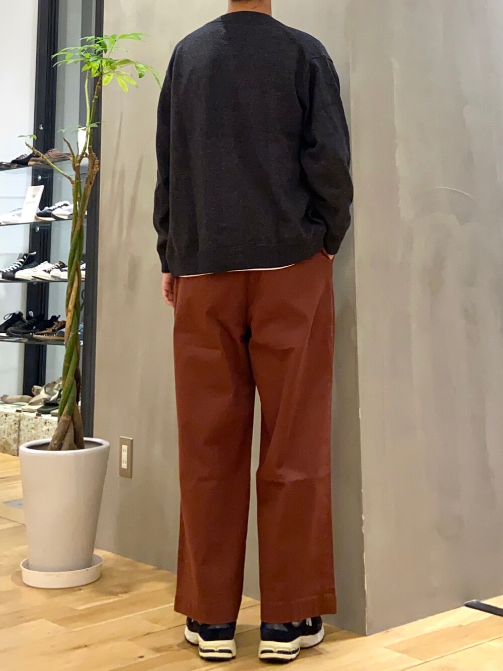 ブラック系のカーディガン/ボレロ、ホワイト系のTシャツ/カットソー、オレンジ系のチノパンツを着用したメンズの秋コーディネートの3枚目の写真