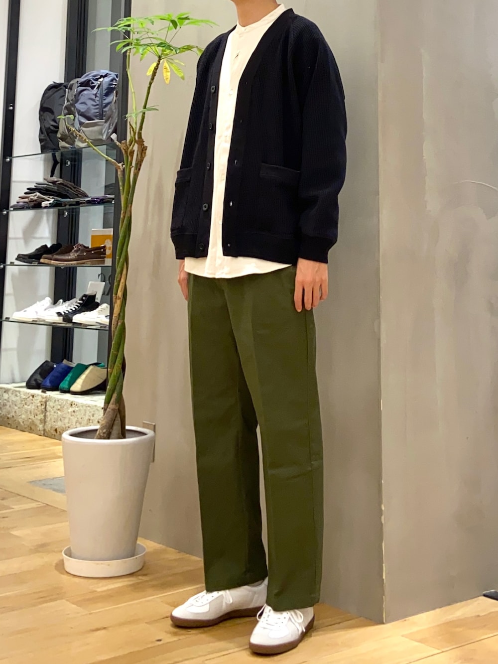 ブラック系のカーディガン/ボレロ、ベージュ系のシャツ/ブラウス、ホワイト系のスニーカーを着用したメンズの秋コーディネートの2枚目の写真