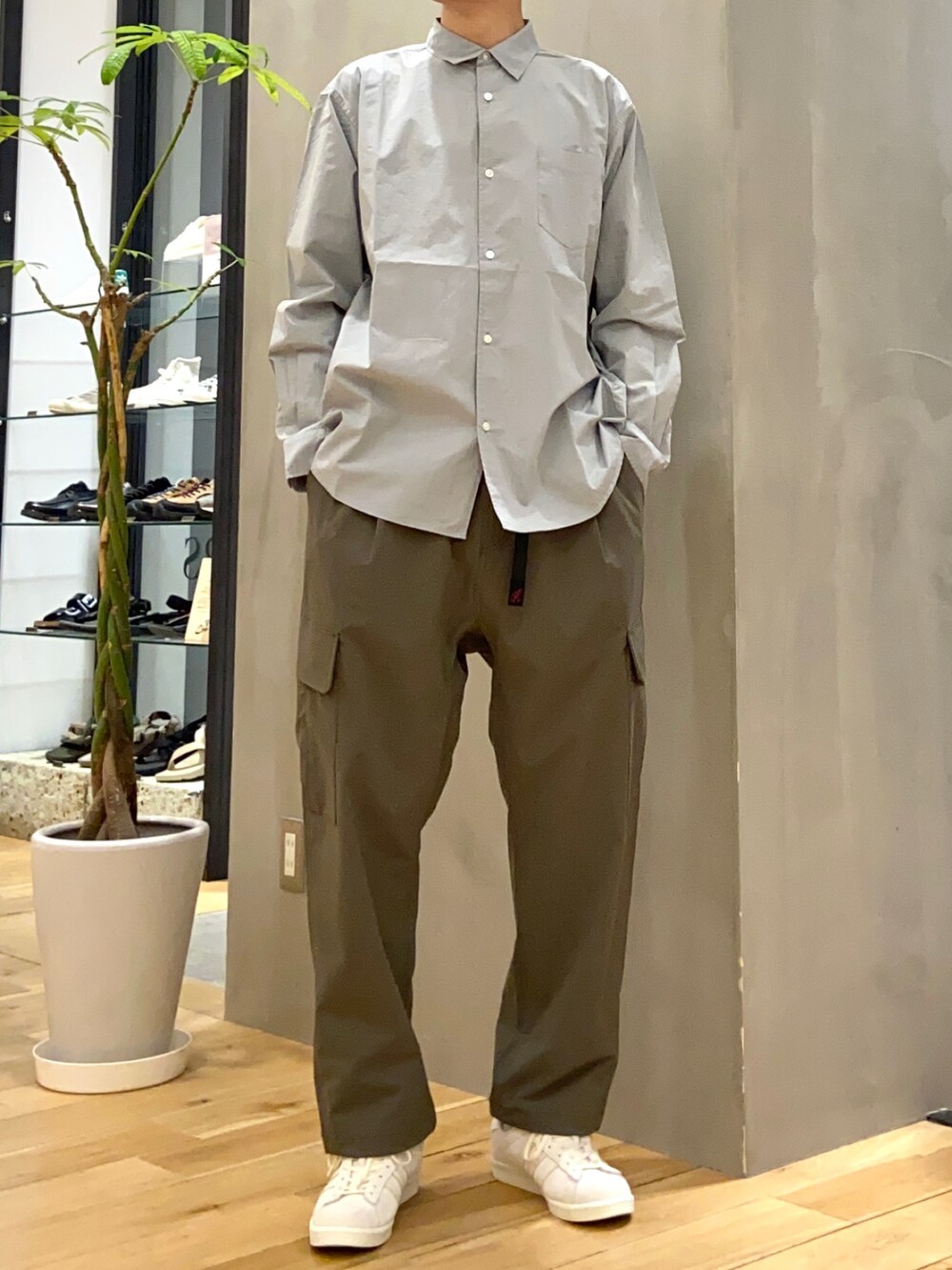 ブラック系のミリタリージャケット、ブルー系のシャツ/ブラウス、ベージュ系のスニーカーを着用したメンズの春コーディネートの2枚目の写真