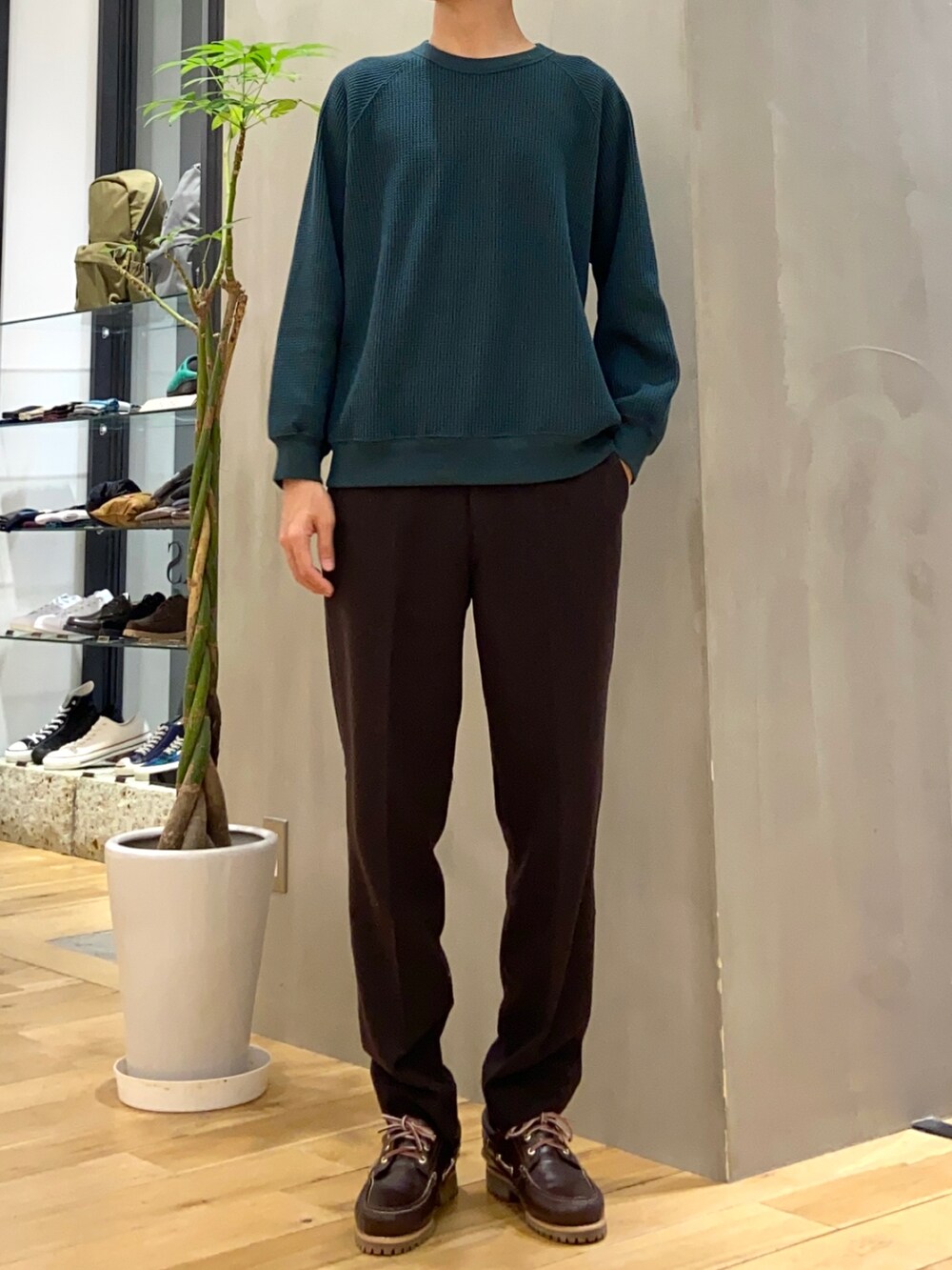 ベージュ系のダウンジャケット/コート、グリーン系のTシャツ/カットソー、ブラウン系のスニーカーを着用したメンズの冬コーディネートの2枚目の写真