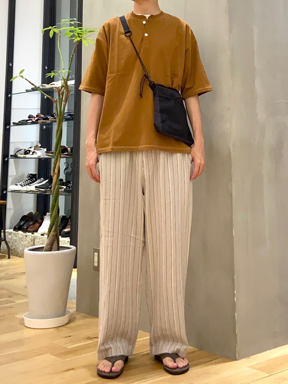 ブラウン系のTシャツ/カットソー、ベージュ系のその他パンツ、グレー系のサンダルを着用したメンズの夏コーディネートの3枚目の写真