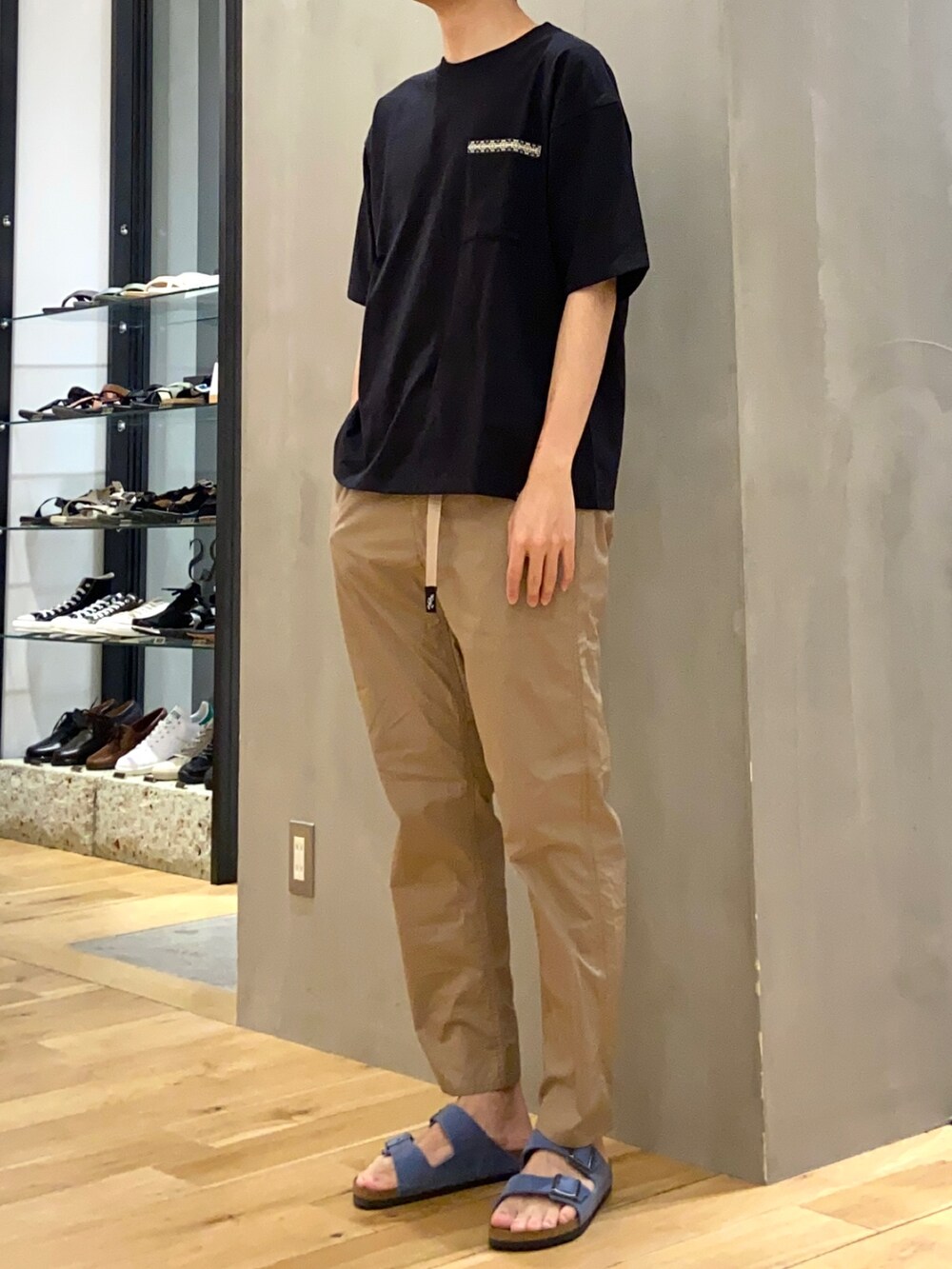 ブラック系のTシャツ/カットソー、ベージュ系のその他パンツ、ブルー系のサンダルを着用したメンズの夏コーディネートの2枚目の写真