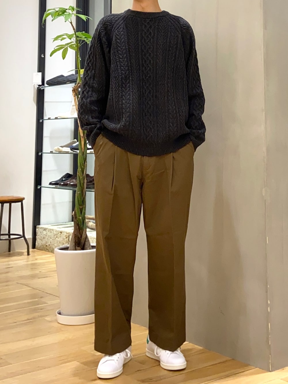 グリーン系のブルゾン、グレー系のニット/セーター、ホワイト系のスニーカーを着用したメンズの冬コーディネートの2枚目の写真