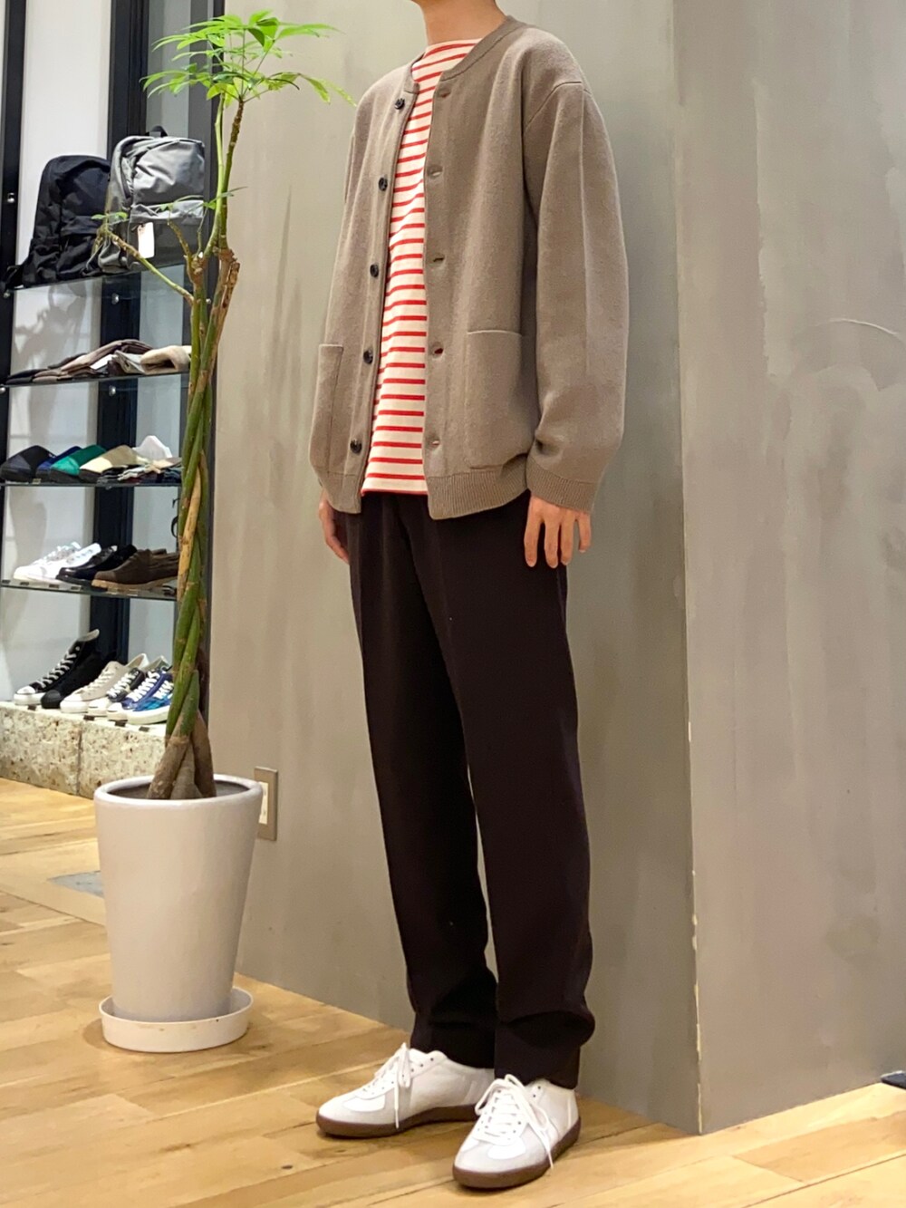 ブラウン系のカーディガン/ボレロ、グレー系のTシャツ/カットソー、ホワイト系のスニーカーを着用したメンズの冬コーディネートの2枚目の写真