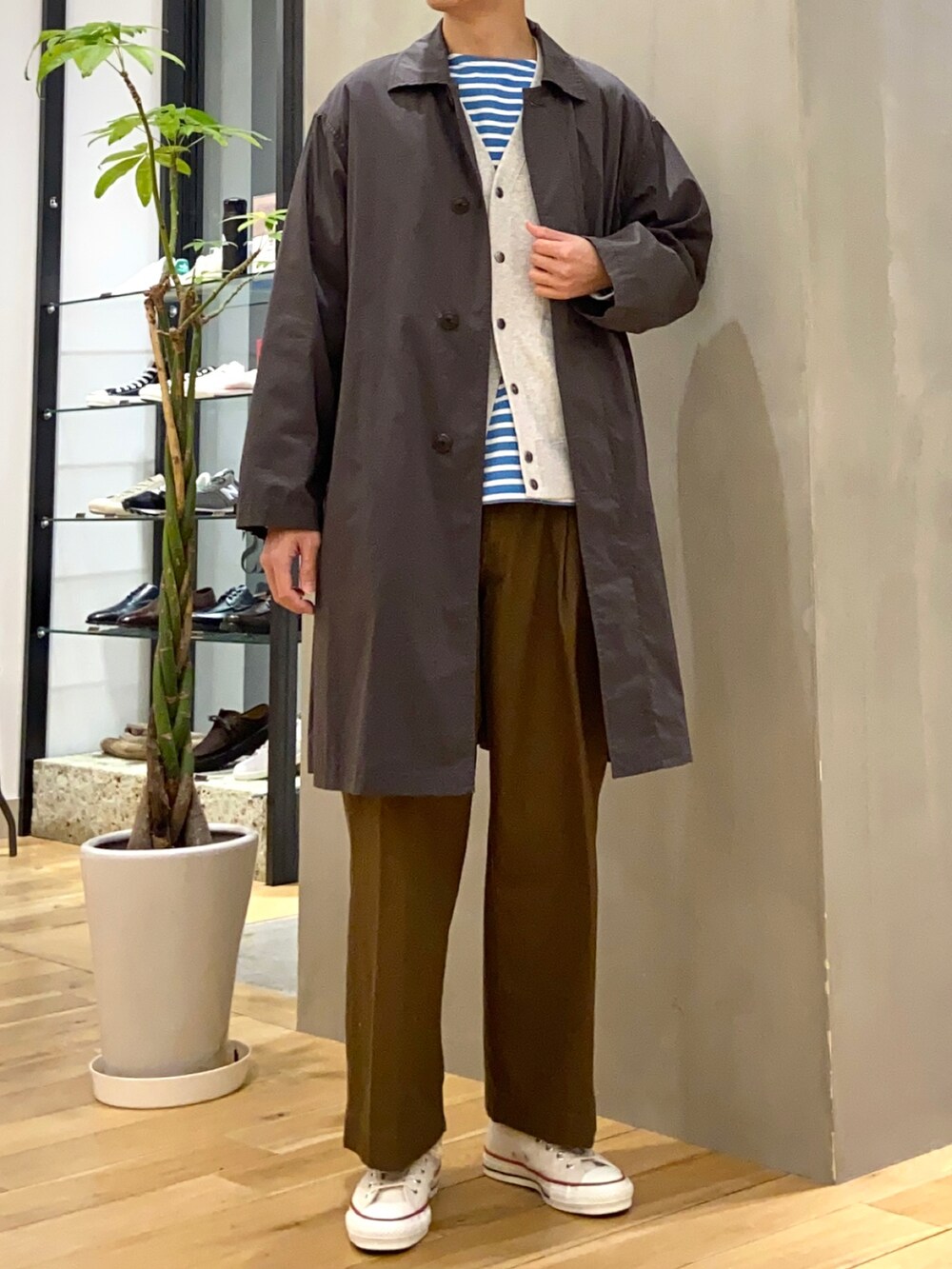 グレー系のステンカラーコート、グレー系のカーディガン/ボレロ、ブラウン系のその他パンツを着用したメンズの冬コーディネートの4枚目の写真