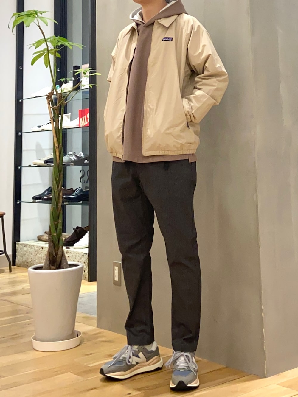 ブラウン系のパーカー、グレー系のその他パンツ、グレー系のスニーカーを着用したメンズの春コーディネートの2枚目の写真