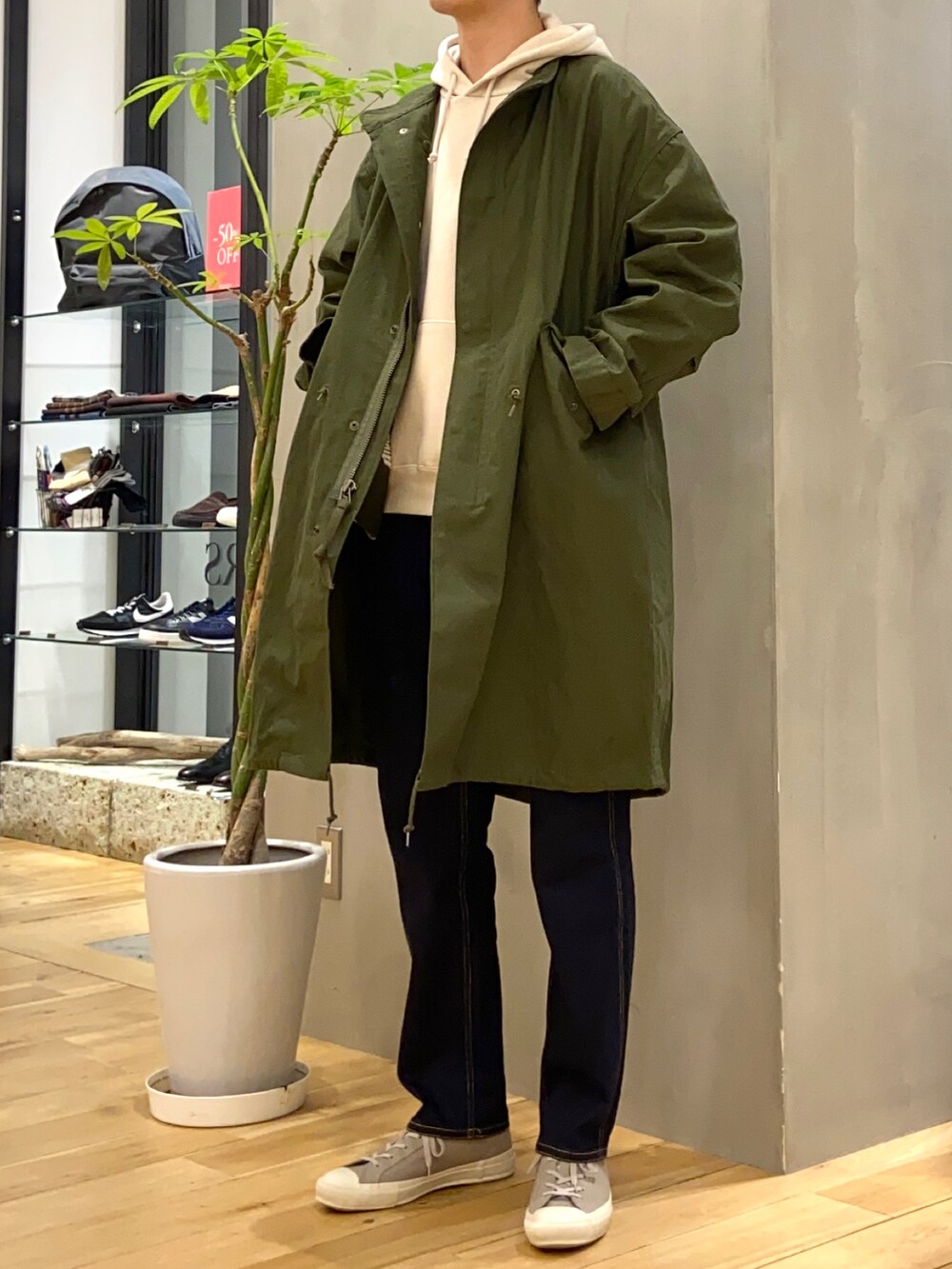 グリーン系のモッズコート、ベージュ系のパーカー、ブルー系のその他パンツを着用したメンズの冬コーディネートの2枚目の写真