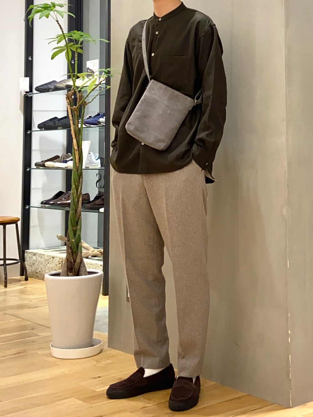 ブラウン系のシャツ/ブラウス、グレー系のショルダーバッグ、ブラウン系のローファーを着用したメンズの冬コーディネートの2枚目の写真