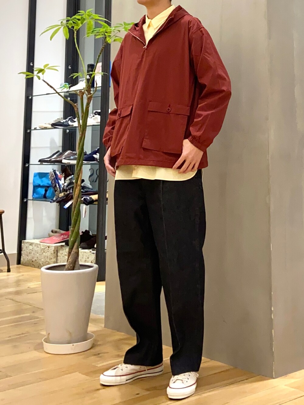 レッド系のマウンテンパーカー、イエロー系のシャツ/ブラウス、ブルー系のデニムパンツを着用したメンズの冬コーディネートの4枚目の写真