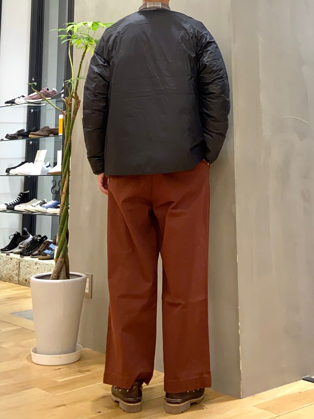 ブラック系のダウンジャケット/コート、オレンジ系のその他パンツを着用したメンズの秋コーディネートの3枚目の写真