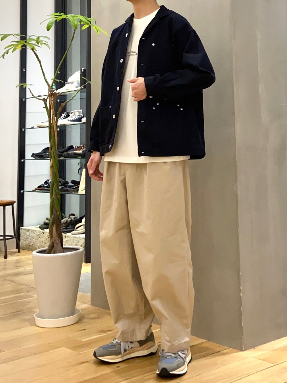 ブラック系のその他アウター、ホワイト系のTシャツ/カットソー、ベージュ系のその他パンツを着用したメンズの春コーディネートの2枚目の写真