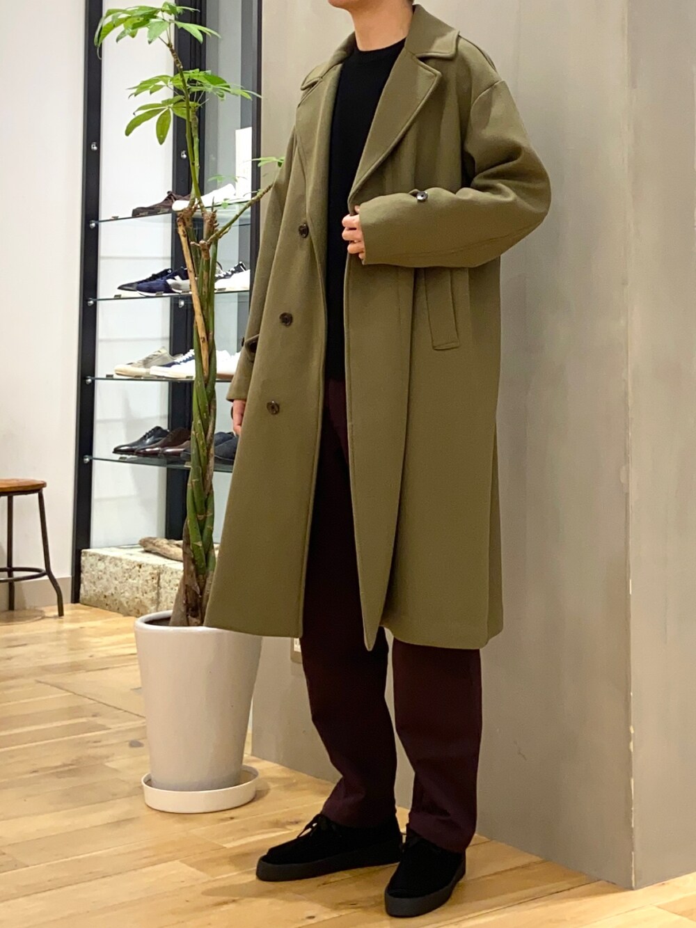 ブラック系のニット/セーター、グリーン系のチェスターコート、ブラック系のその他シューズを着用したメンズの冬コーディネートの4枚目の写真