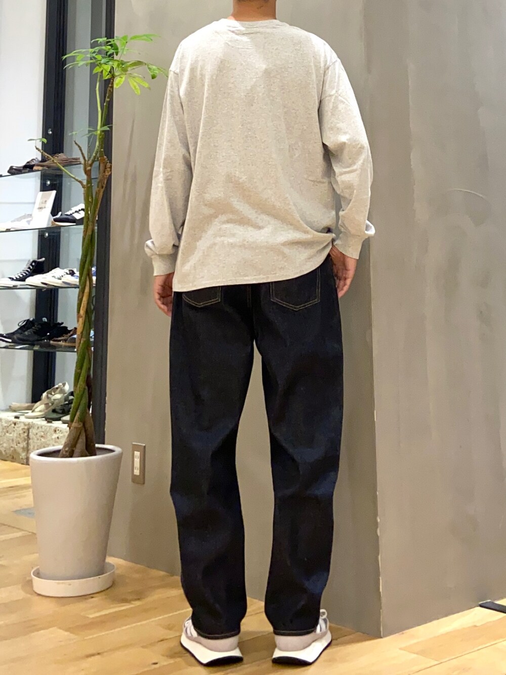 グレー系のTシャツ/カットソー、ブルー系のデニムパンツを着用したメンズの秋コーディネートの3枚目の写真