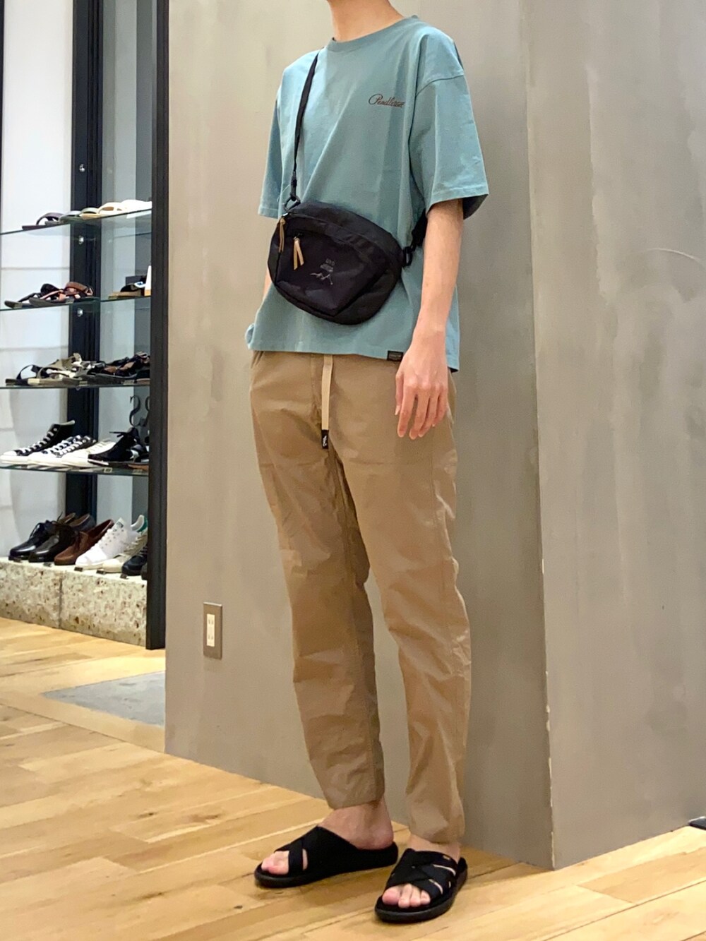 グリーン系のTシャツ/カットソー、ブラック系のショルダーバッグ、ベージュ系のその他パンツを着用したメンズの春コーディネートの3枚目の写真