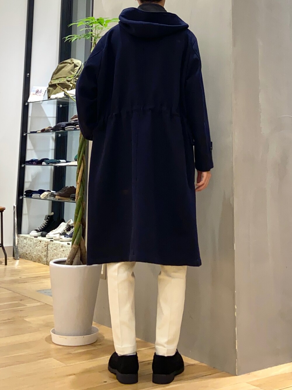 ブルー系のダッフルコート、グレー系のニット/セーター、ホワイト系のチノパンツを着用したメンズの秋コーディネートの3枚目の写真