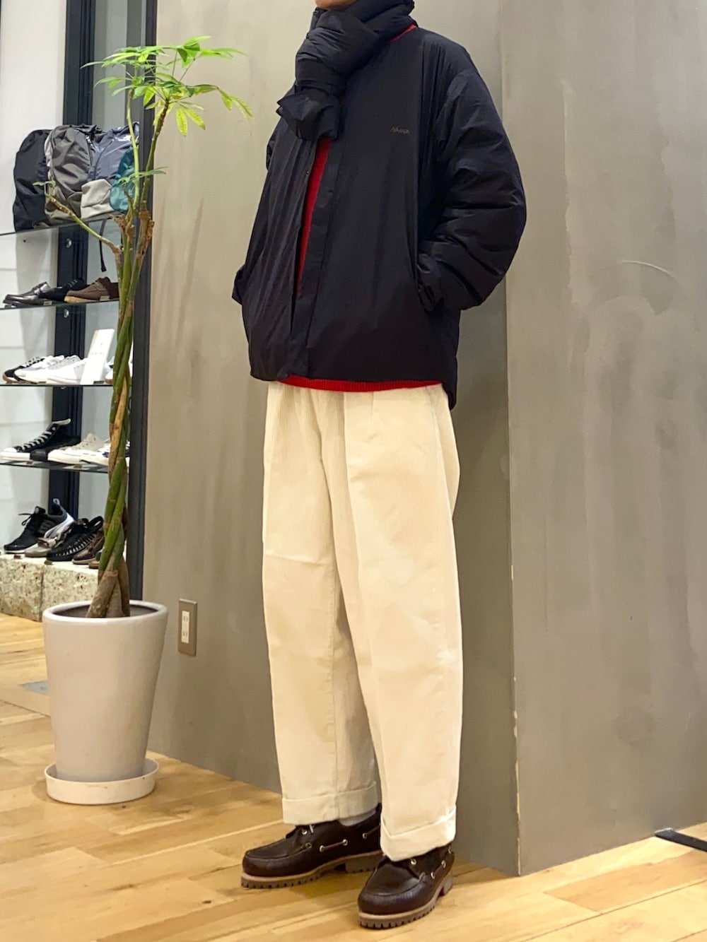 ブラック系のダウンジャケット/コート、レッド系のニット/セーター、ホワイト系のその他パンツを着用したメンズの秋コーディネートの3枚目の写真
