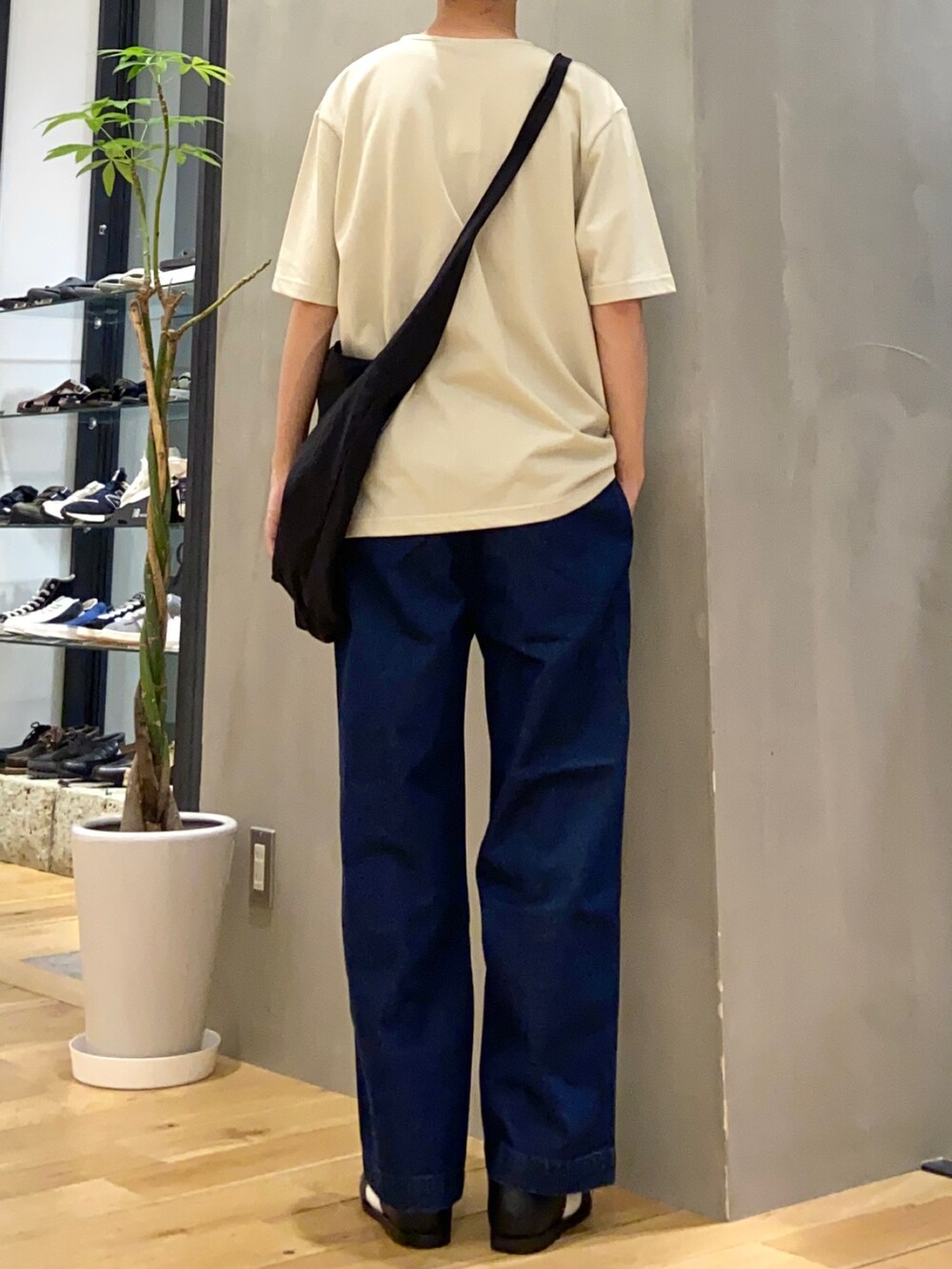 ホワイト系のTシャツ/カットソー、ブラック系のショルダーバッグ、ブルー系のデニムパンツを着用したメンズの春コーディネートの3枚目の写真