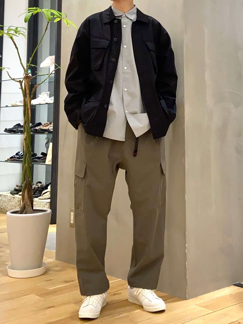 ブラック系のミリタリージャケット、ブルー系のシャツ/ブラウス、ベージュ系のスニーカーを着用したメンズの春コーディネートの4枚目の写真