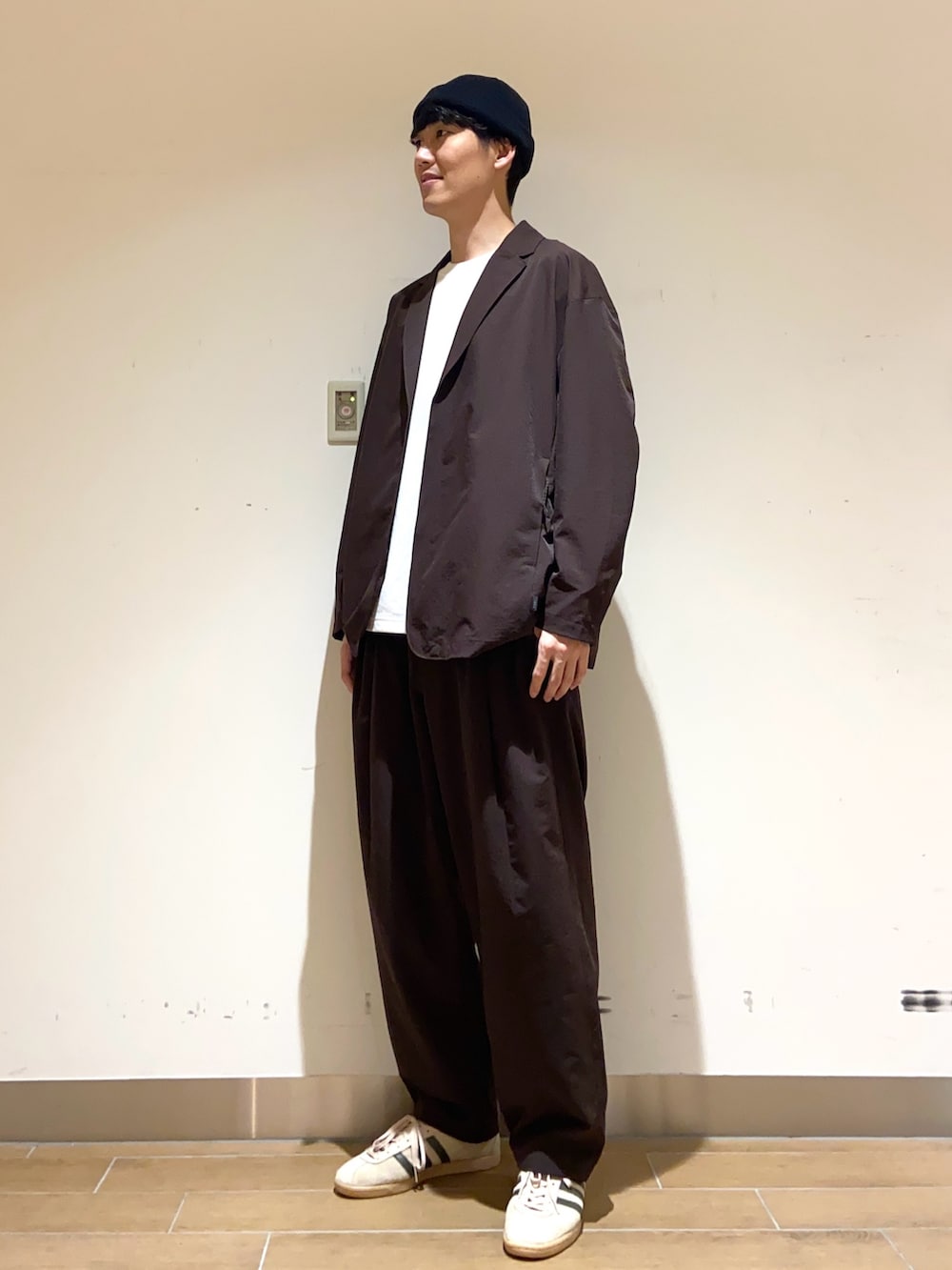 ブラウン系のその他アウター、ブラウン系のその他パンツ、ホワイト系のTシャツ/カットソーを着用したメンズの春コーディネートの2枚目の写真