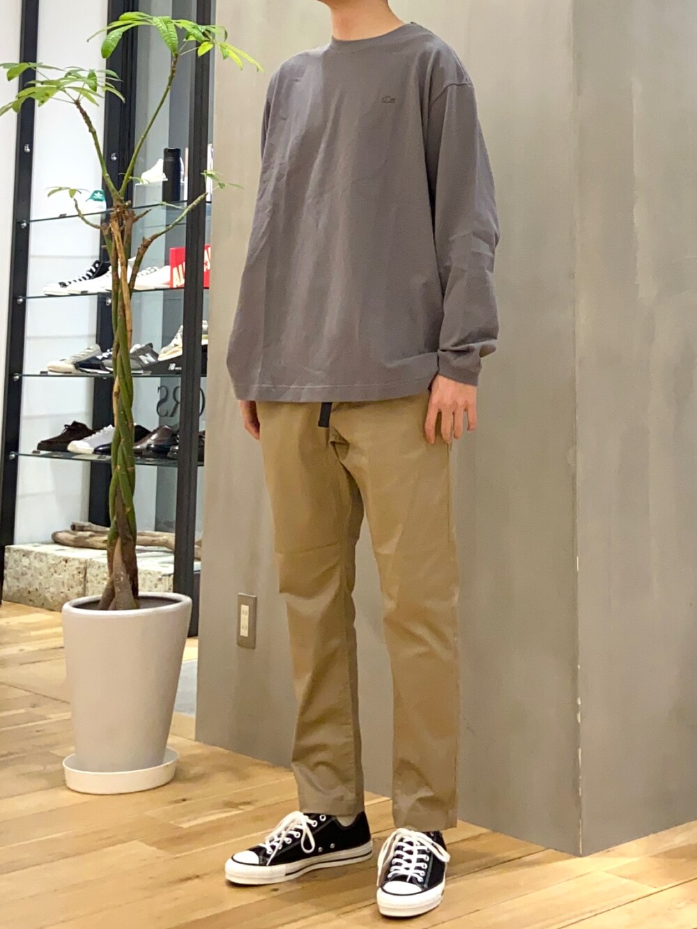 グレー系のTシャツ/カットソー、グリーン系のステンカラーコート、ベージュ系のその他パンツを着用したメンズの春コーディネートの5枚目の写真