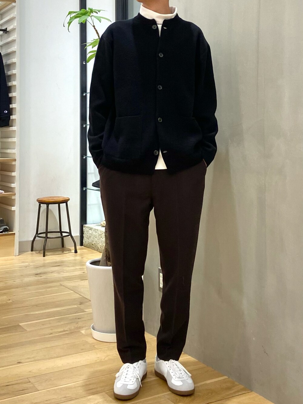 ホワイト系のステンカラーコート、ブラック系のカーディガン/ボレロ、ホワイト系のTシャツ/カットソーを着用したメンズの冬コーディネートの2枚目の写真