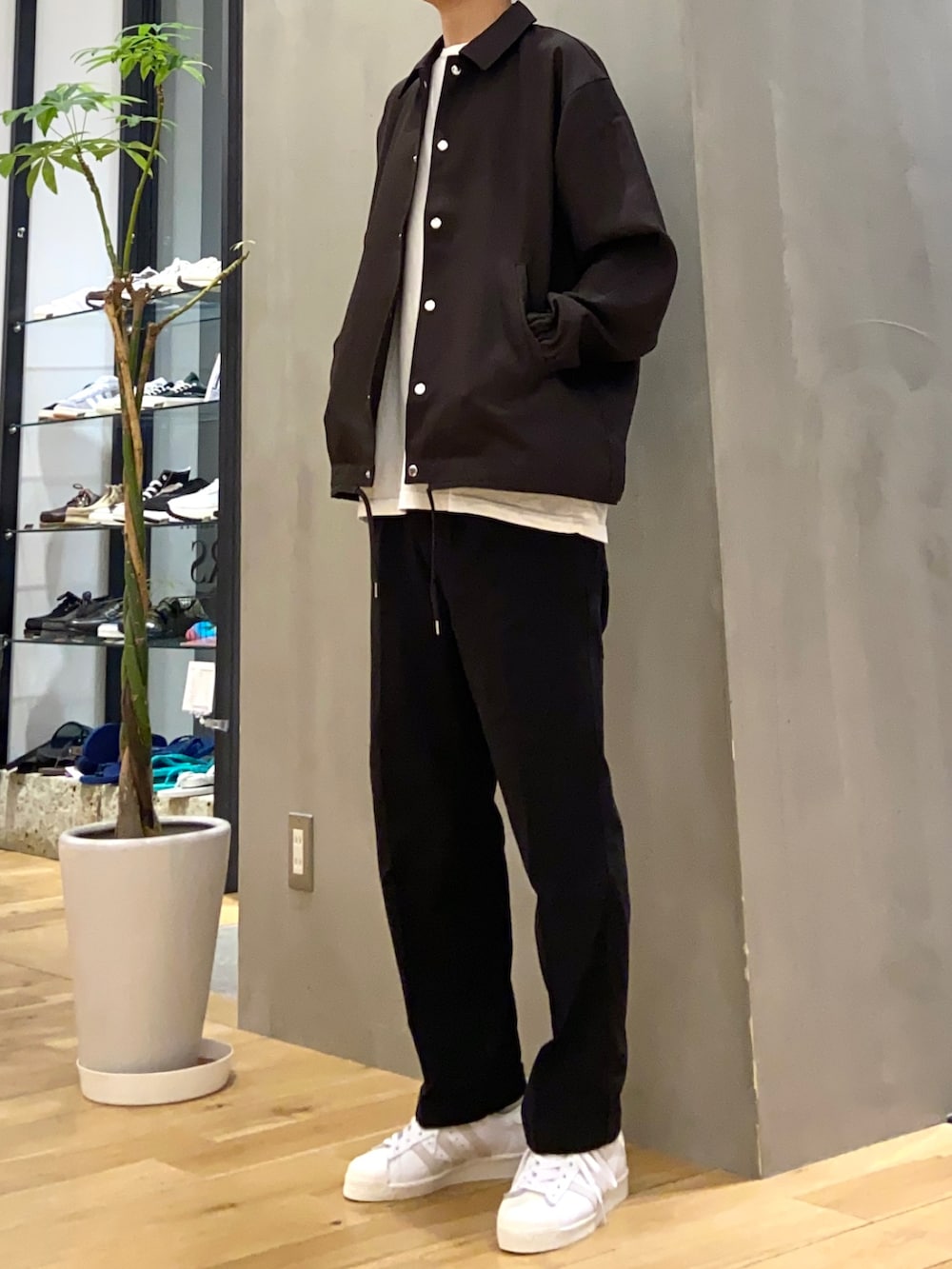 ブラウン系のセットアップ、ホワイト系のスニーカー、ブラック系のその他パンツを着用したメンズの夏コーディネートの3枚目の写真