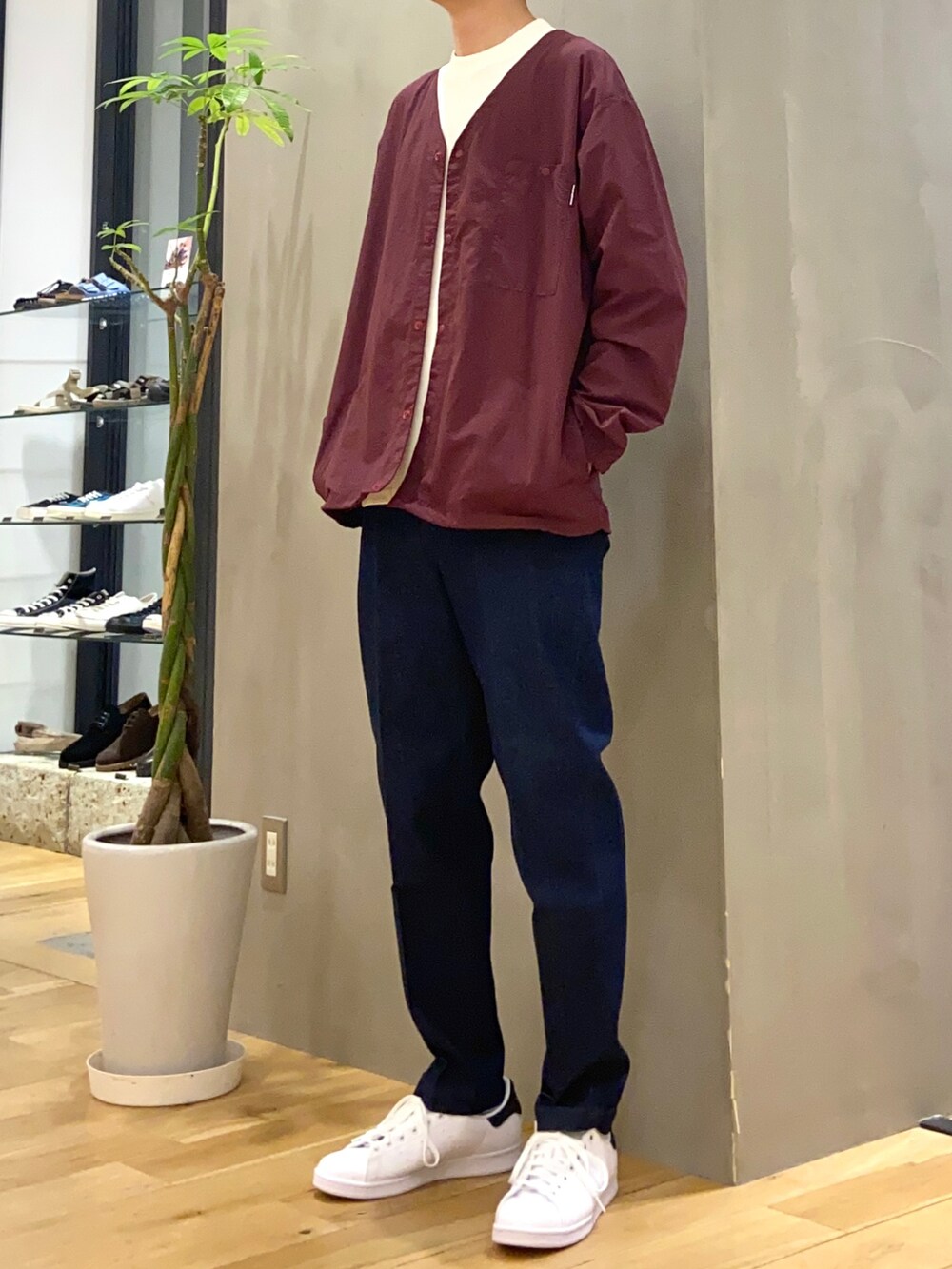 レッド系のブルゾン、ホワイト系のTシャツ/カットソー、ブルー系のデニムパンツを着用したメンズの秋コーディネートの2枚目の写真