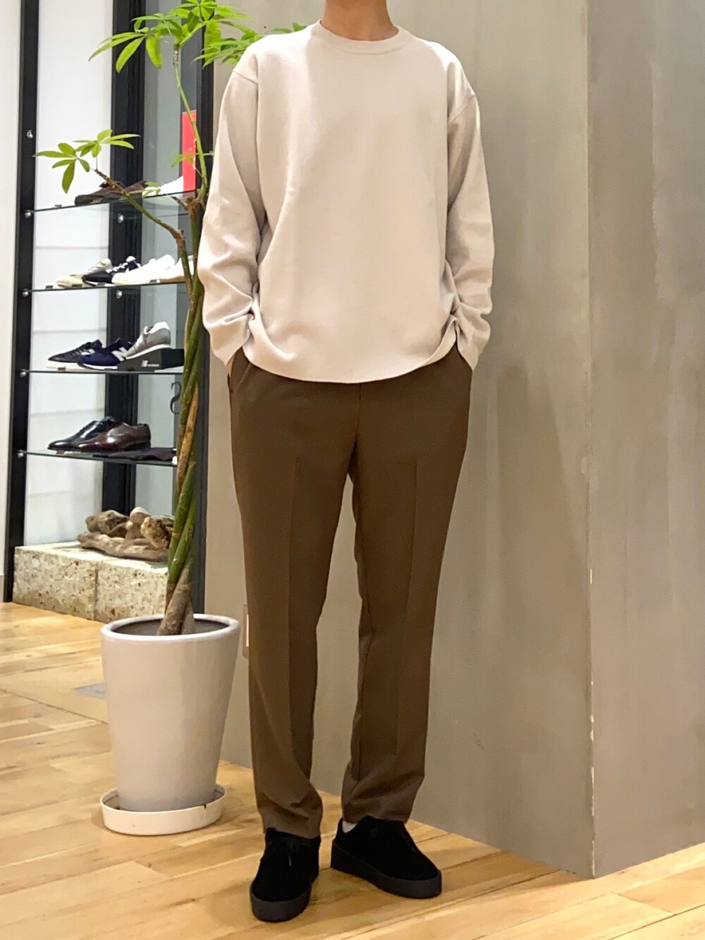 グリーン系のダウンジャケット/コート、ホワイト系のニット/セーター、ブラック系のその他シューズを着用したメンズの冬コーディネートの2枚目の写真