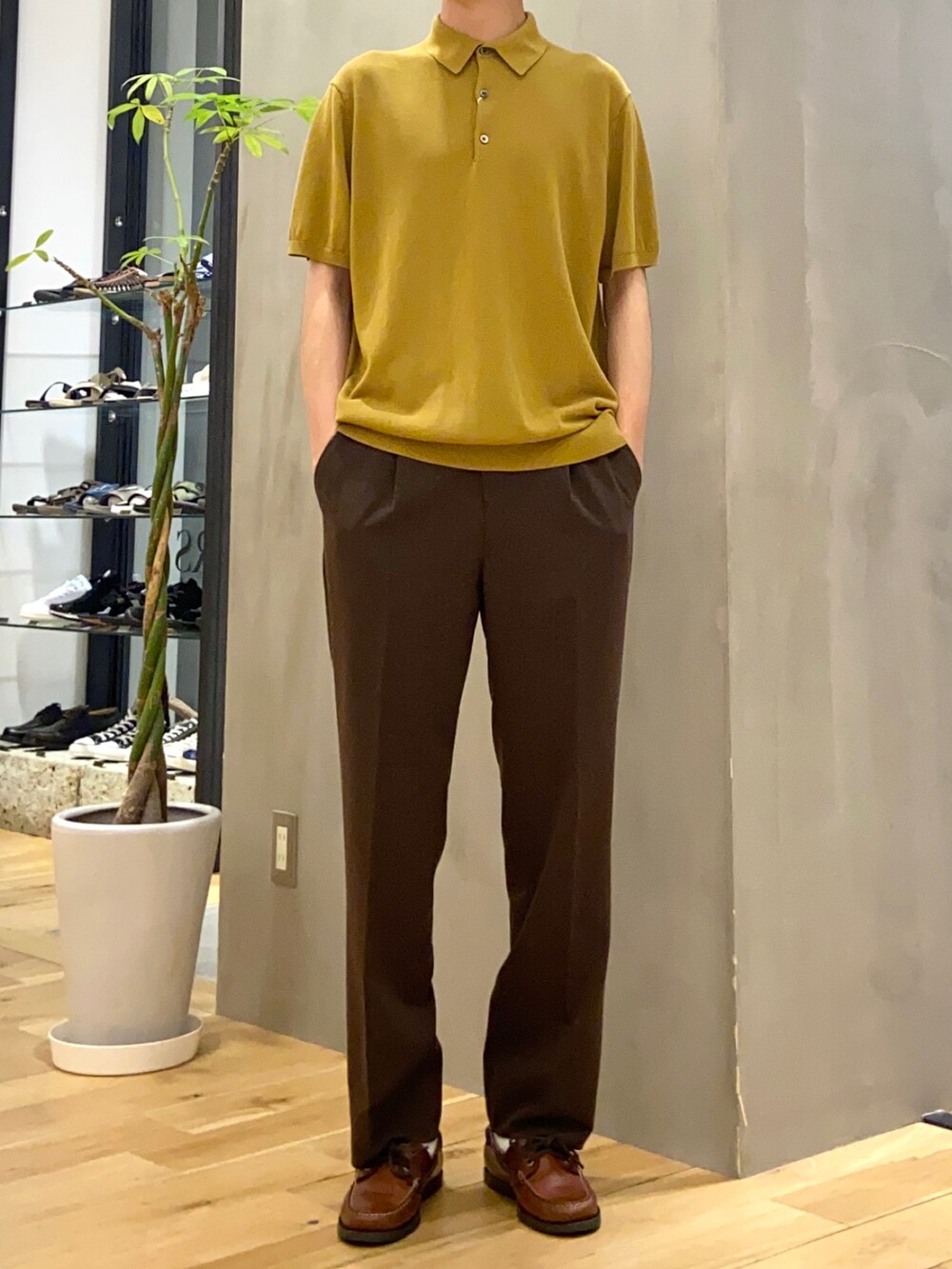 イエロー系のポロシャツ、ブラウン系のその他パンツを着用したメンズの夏コーディネートの4枚目の写真