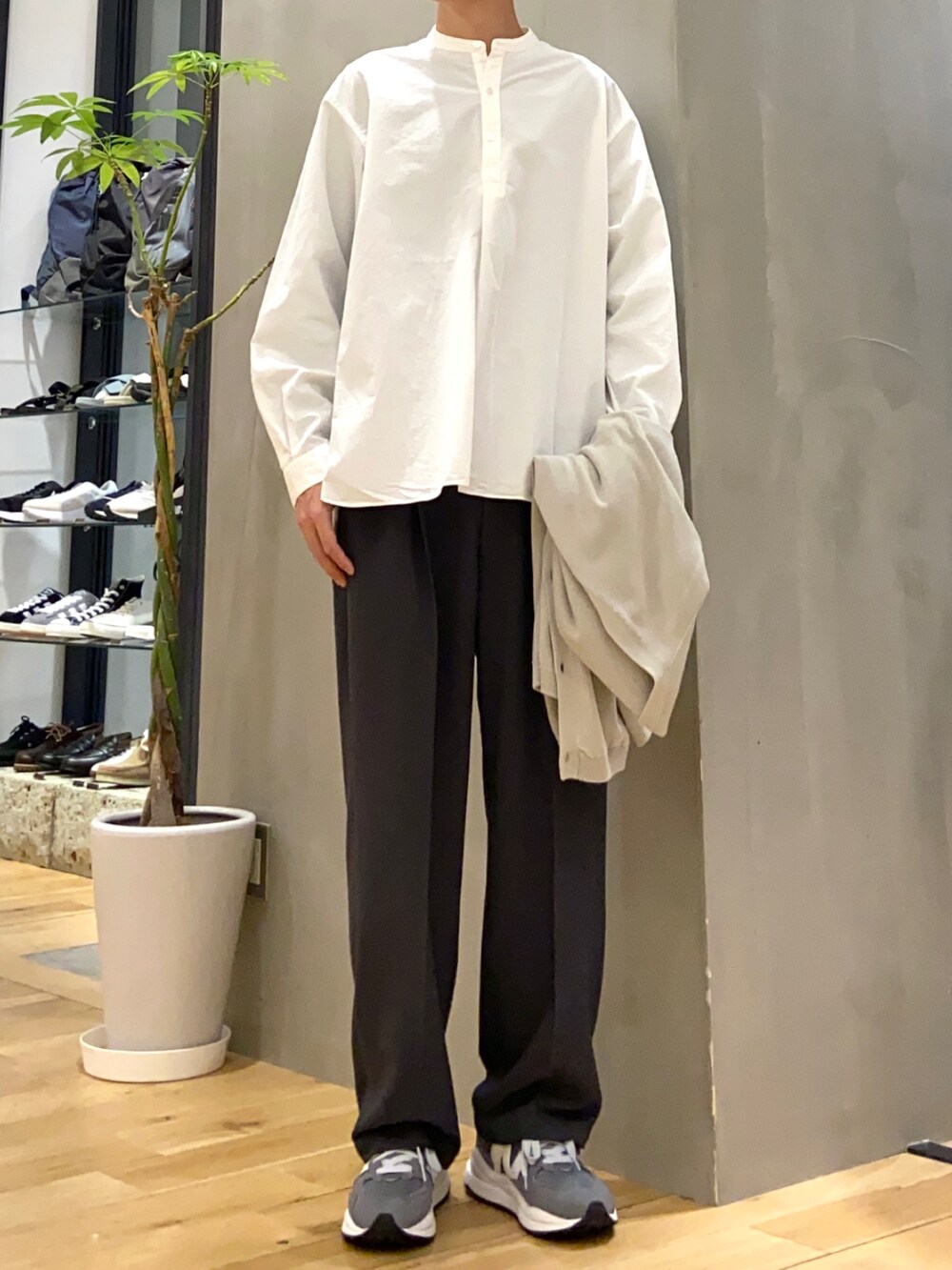 グレー系のカーディガン/ボレロ、ホワイト系のシャツ/ブラウス、グレー系のスラックスを着用したメンズの春コーディネートの2枚目の写真