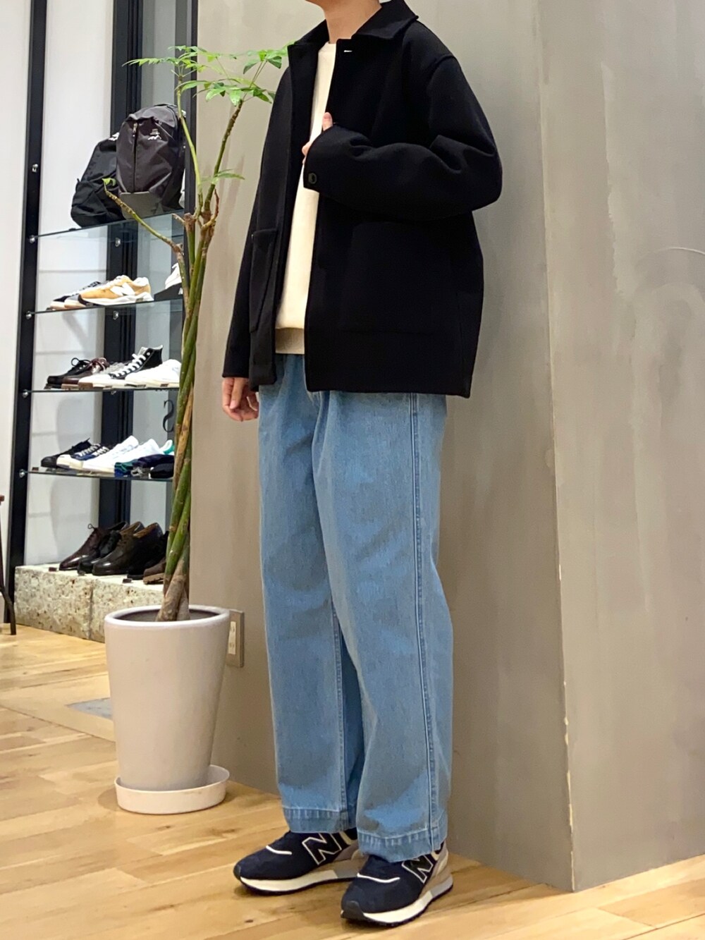 ブラック系のカバーオール、ホワイト系のスウェット、ブルー系のデニムパンツを着用したメンズの春コーディネートの3枚目の写真