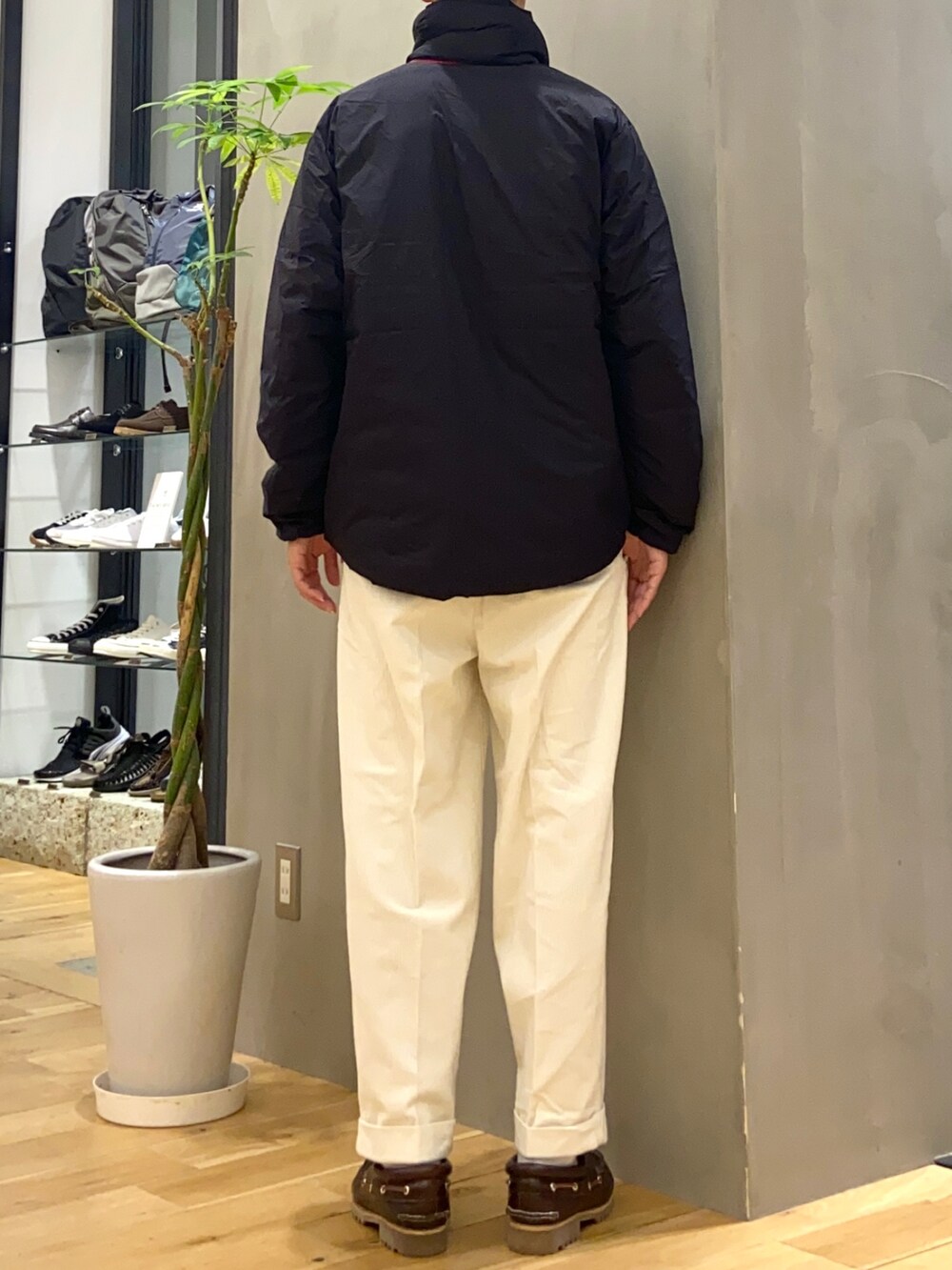ブラック系のダウンジャケット/コート、レッド系のニット/セーター、ホワイト系のその他パンツを着用したメンズの秋コーディネートの4枚目の写真