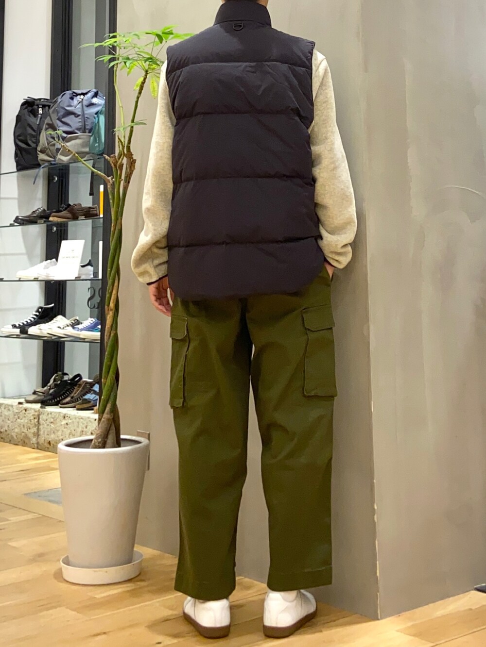 ブラック系のダウンベスト、グリーン系のカーゴパンツ、ホワイト系のスニーカーを着用したメンズの秋コーディネートの3枚目の写真