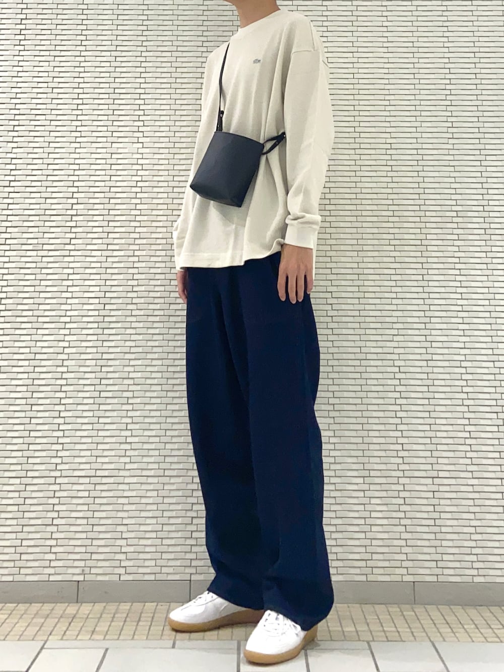 ホワイト系のTシャツ/カットソー、ブラック系のショルダーバッグ、ブルー系のデニムパンツを着用したメンズの秋コーディネートの2枚目の写真