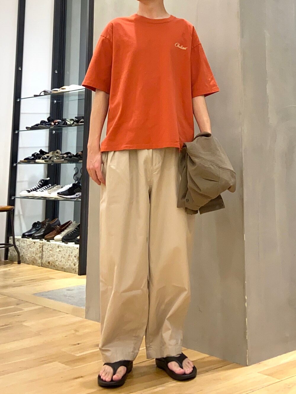 グリーン系のブルゾン、レッド系のTシャツ/カットソー、ベージュ系のその他パンツを着用したメンズの夏コーディネートの2枚目の写真