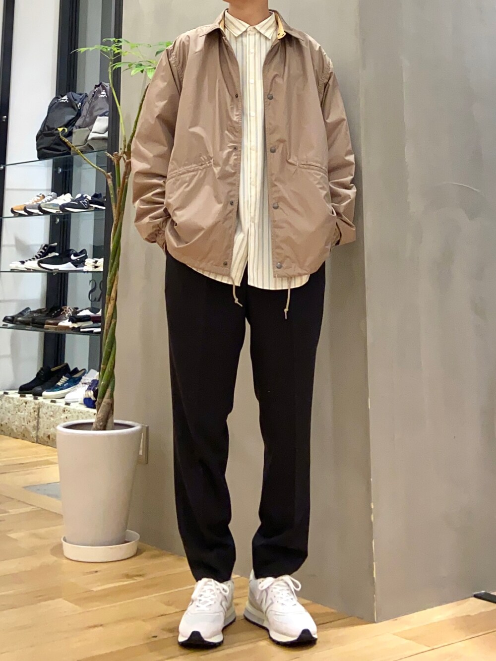 ホワイト系のシャツ/ブラウス、ブラック系のスラックス、ホワイト系のスニーカーを着用したメンズの春コーディネートの2枚目の写真