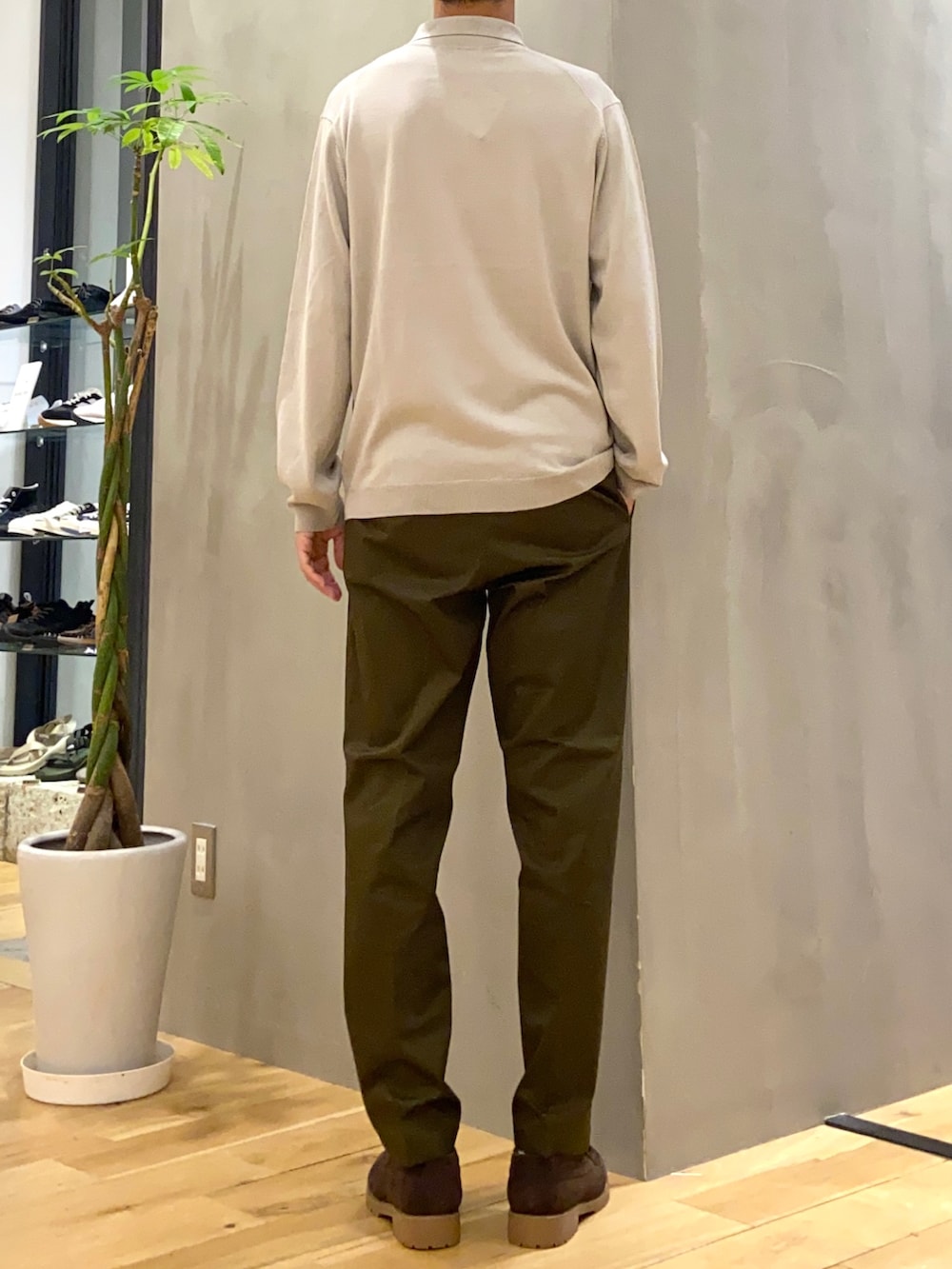グレー系のポロシャツ、グリーン系のスーツパンツ、ブラウン系のその他シューズを着用したメンズの秋コーディネートの3枚目の写真