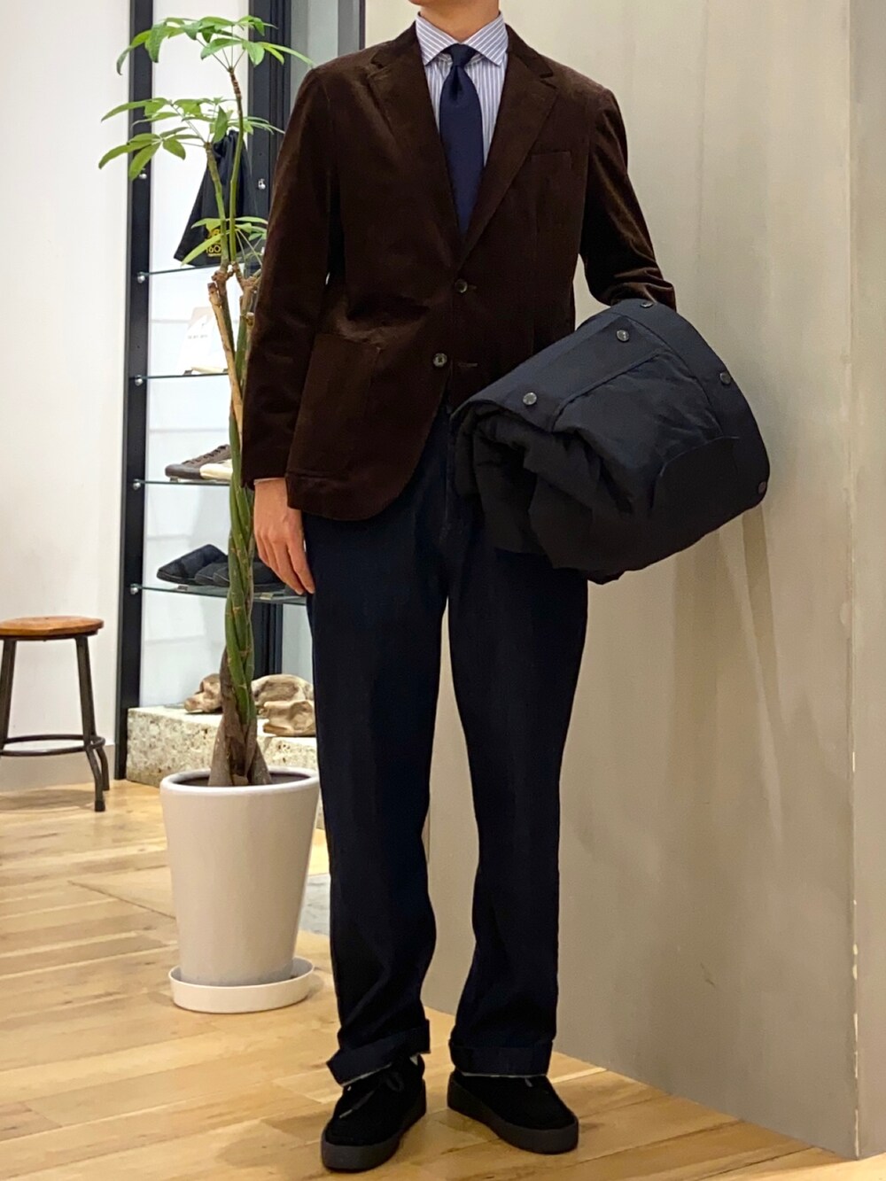ブラック系のその他アウター、ブラウン系のスーツジャケット、ブルー系のデニムパンツを着用したメンズの秋コーディネートの2枚目の写真