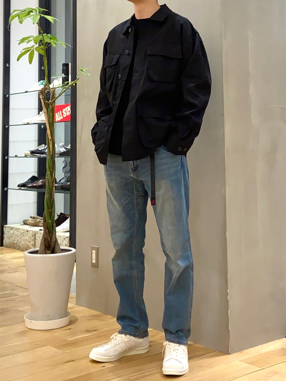 ブラック系のミリタリージャケット、ブラック系のニット/セーター、ブルー系のその他パンツを着用したメンズの春コーディネートの4枚目の写真